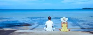 Couple sitting together beside the sea