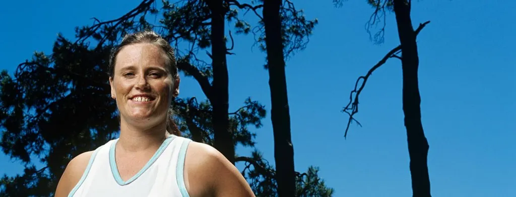 Woman standing outdoors among trees