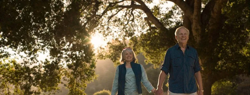 Older couple walking through a park