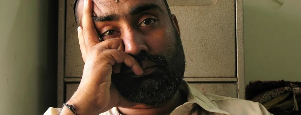 Man sitting with a hand against his face