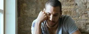 Man sitting with his hand against his face