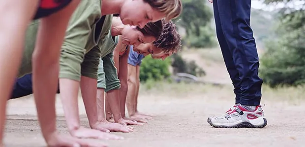 Group exercising outdoors with an instructor
