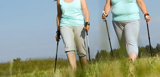 Two women walking with hiking poles