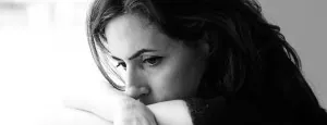 Woman resting her face against her arm