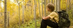 Young hiker resting in an autumn forest