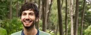 Man smiling in a wooded setting
