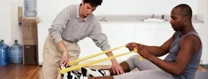 Physical therapist guiding a man's resistance-band exercise