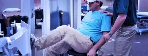 Man using rehabilitation equipment with assistance