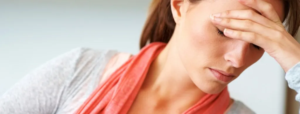 Woman resting her forehead on her hand