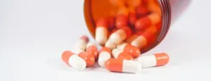 Tablets and capsules spilling from a medicine bottle