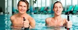 Two people exercising with aquatic resistance equipment in a pool