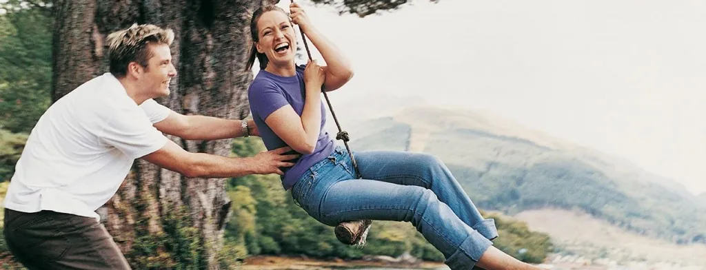 Couple talking beside a wooden fence in the mountains