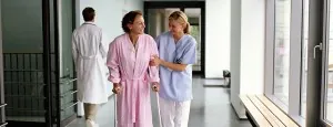 Clinician walking with a person in a hospital corridor