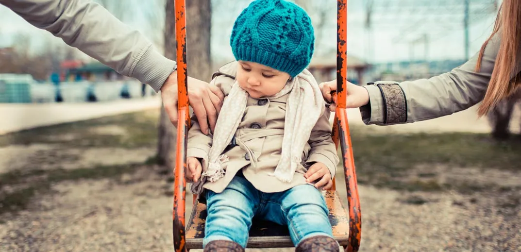 Parents decided on one baby after-premarriage counseling questions Child in a swing with adults nearby