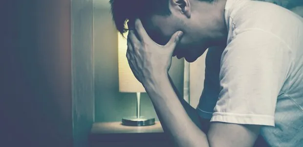 Man sitting with his head in his hand