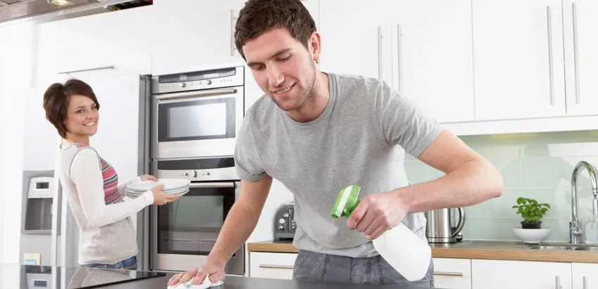Couple doing chores after premarriage-counseling questions Couple cleaning a kitchen