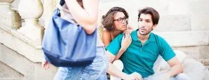 Seated couple watching another person walk past