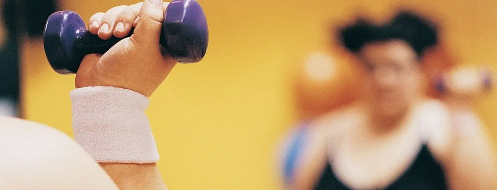 Person lifting a dumbbell during an exercise class