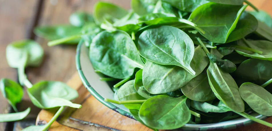 Fresh spinach leaves in a glass bowl
