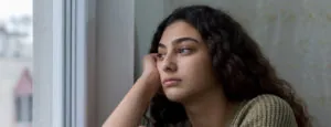 Young woman looking out of a window