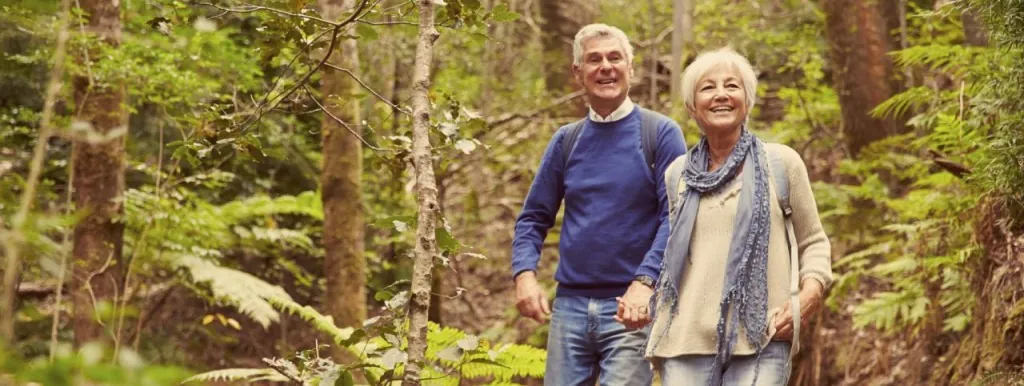 Older couple walking along a woodland trail