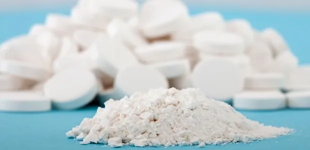 White tablets beside crushed powder