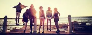 Group of young people standing together at sunset