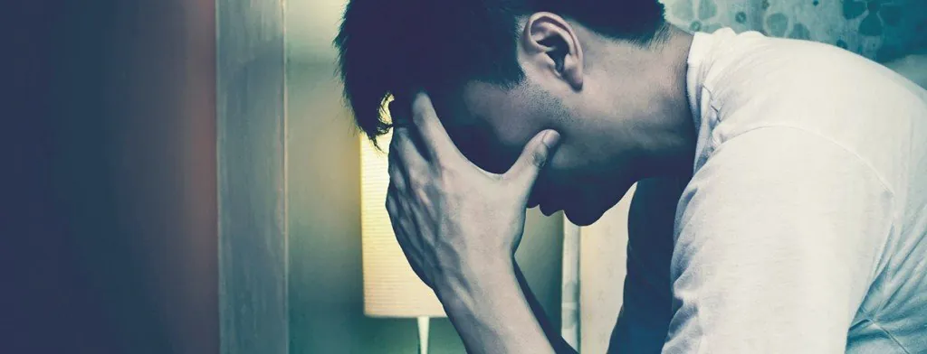 Man sitting with his head in his hand