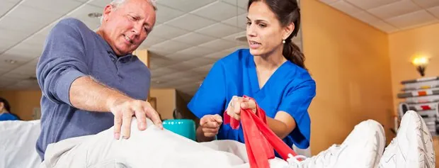 Nurse discussing recovery with a man in a hospital bed