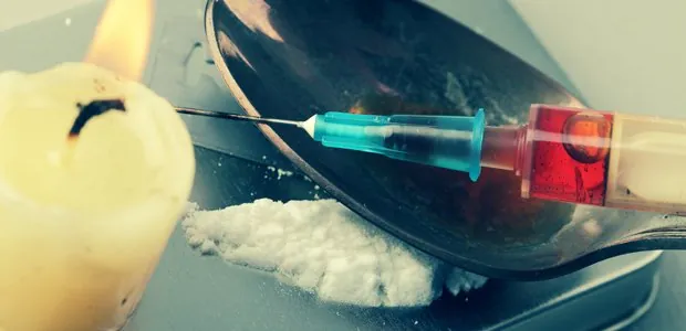 Syringe beside a candle and spoon