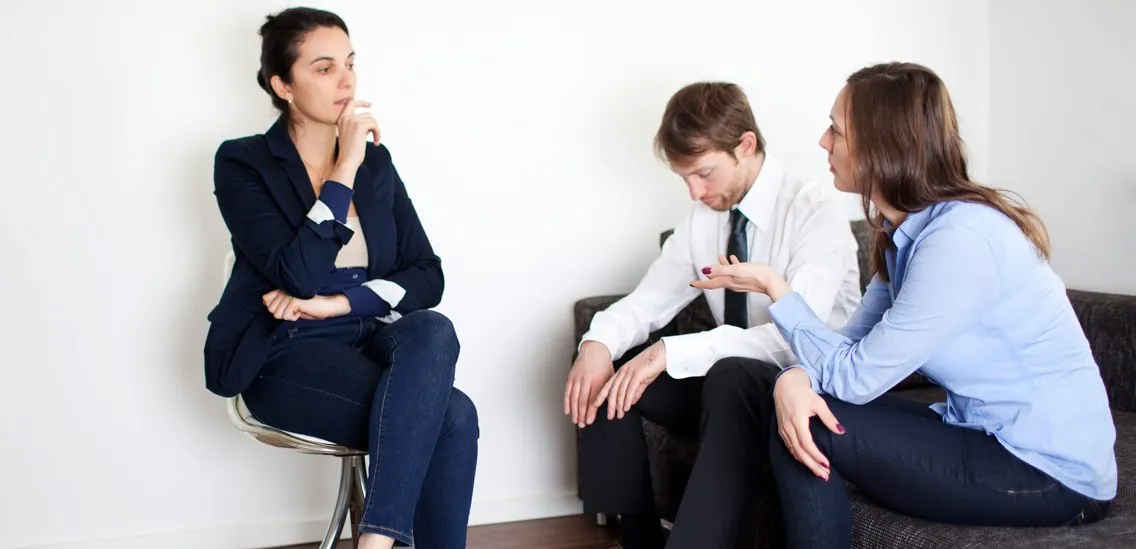 A couple speaking with a therapist in an office