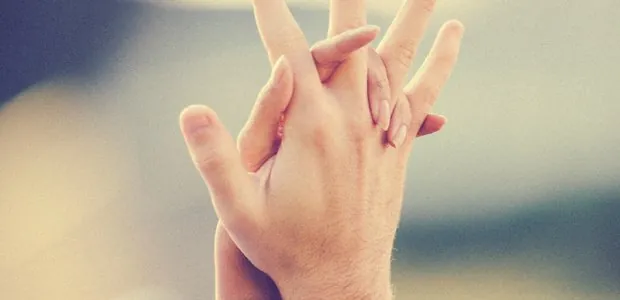 Two hands with fingers interlaced