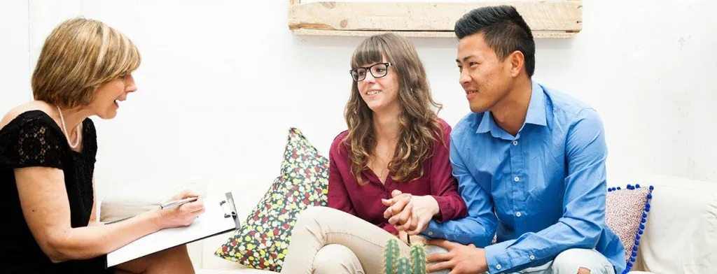 Couple speaking with a counselor on a sofa
