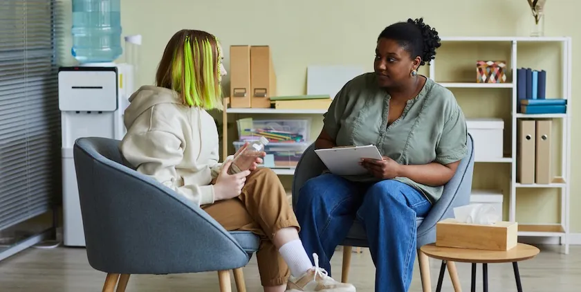 Young person speaking with a counselor in an office