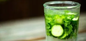 Glass of water with cucumber and herbs