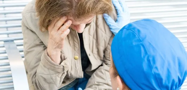 Clinician supporting a woman with her head in her hands