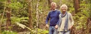 Older couple walking along a woodland trail