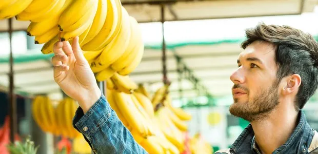 Man choosing bananas at a shop