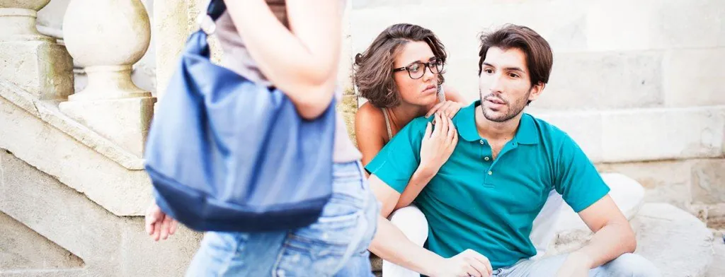 Seated couple watching another person walk past