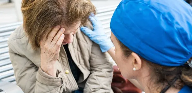 Clinician supporting a woman with her head in her hands