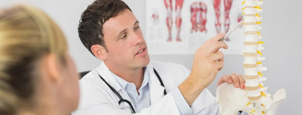 Clinician explaining a spine model to a patient