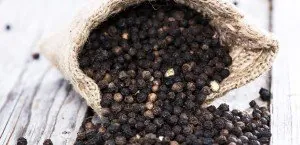 Black peppercorns spilling from a sack