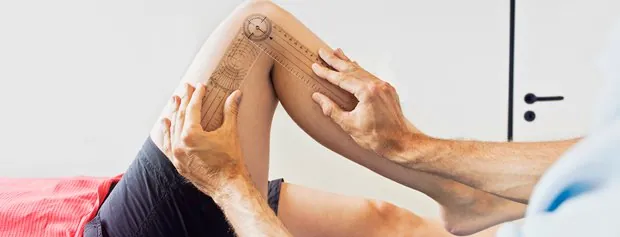Hands supporting a person's knee during an examination