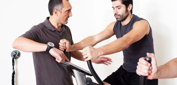 Therapist assisting a man on an exercise bike