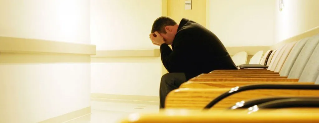 Man sitting with his head in his hands
