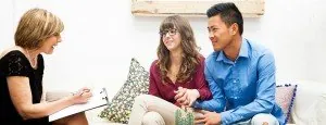 Couple speaking with a counselor on a sofa