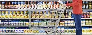 Shopper with a cart in a supermarket aisle