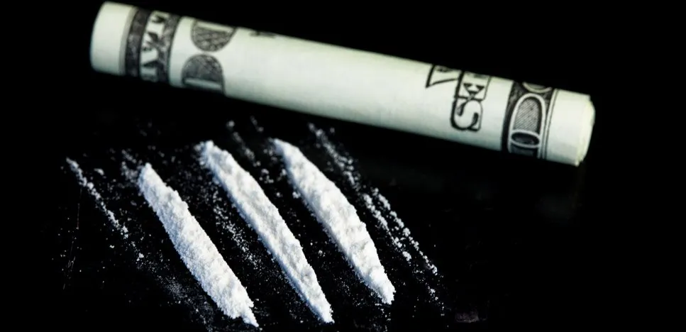 Rolled up bill sign of cocaine use Rolled banknote beside lines of white powder
