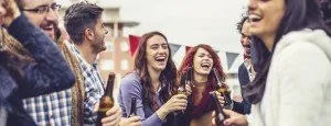 Young people holding drinks at a social gathering