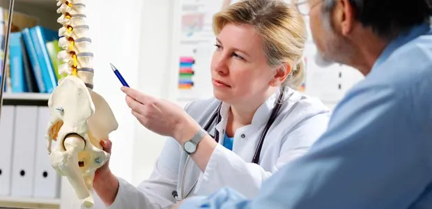 Clinician explaining a spine model to a patient